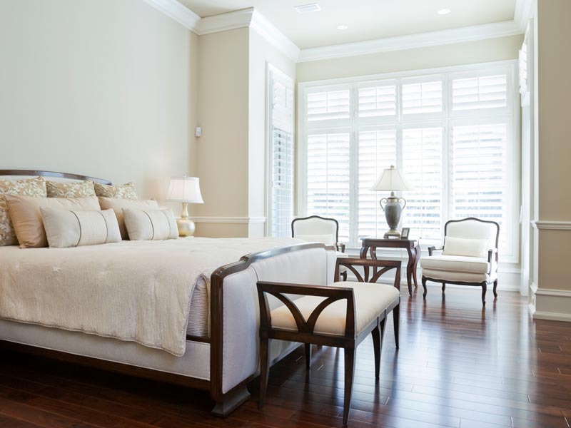 white plantation shutters covering windows in bedroom