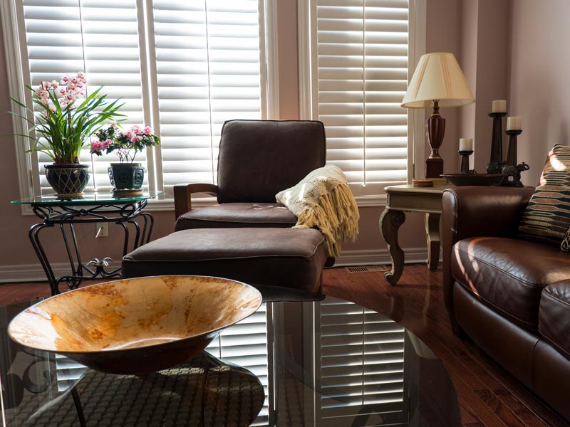 white plantation shutters covering windows in living room