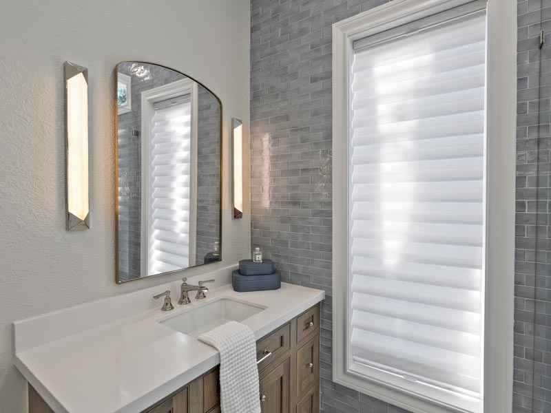 master bathroom with white roman shades covering window